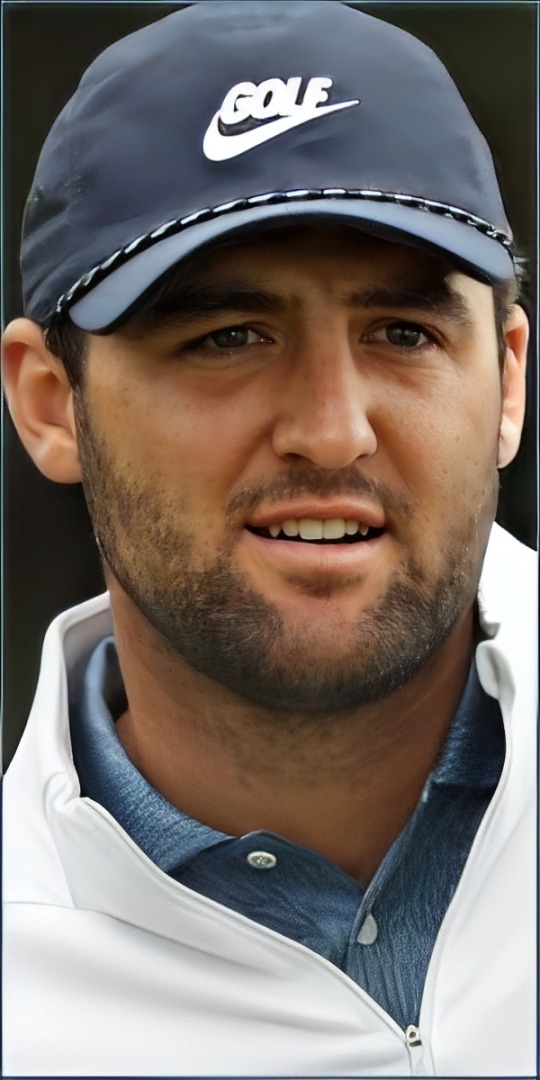A golfer wearing a blue cap and white jacket, focused and engaged